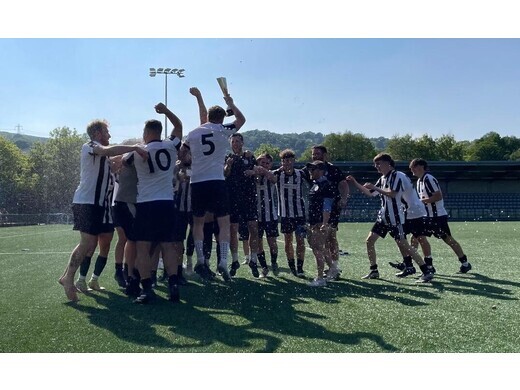Team celebrating a trophy win on the pitch